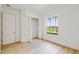 Sunlit bedroom featuring wood floors, closet, and a large window view of the lake and palms at 517 Milano Rd, Poinciana, FL 34759