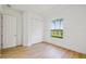 Well-lit bedroom with wood floors, closet, and a window overlooking the palms and lake at 517 Milano Rd, Poinciana, FL 34759