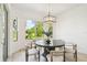 Dining room with nature views from large windows and a modern chandelier at 517 Milano Rd, Poinciana, FL 34759