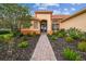Charming home featuring a brick walkway leading to the front door and lush landscaping at 517 Milano Rd, Poinciana, FL 34759