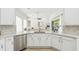 Bright kitchen features white cabinets, stainless steel appliances, stone countertops and tile backsplash at 517 Milano Rd, Poinciana, FL 34759