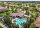 Aerial view of community pool, clubhouse, and meticulously landscaped grounds with lush palm trees at 517 Milano Rd, Poinciana, FL 34759