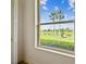 A beautiful view from the window shows palms, lake, and lush greenery at 517 Milano Rd, Poinciana, FL 34759