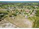 Wide aerial shot showing the home's location within a community near a serene lake at 6006 Country Walk Ln, Winter Haven, FL 33880