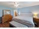 Bright blue bedroom features wood floors, a ceiling fan, a bed with bench, and dresser at 6006 Country Walk Ln, Winter Haven, FL 33880