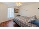 Cozy bedroom with wood floors features ceiling fan and large window with curtains at 6006 Country Walk Ln, Winter Haven, FL 33880