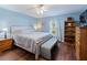 Bright blue bedroom features wood floors, a ceiling fan, a bed with bench, and a bookcase at 6006 Country Walk Ln, Winter Haven, FL 33880