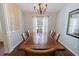 Bright dining room with wood table, seating for six and large window with white curtains at 6006 Country Walk Ln, Winter Haven, FL 33880