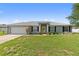 Charming single-story home featuring a well-manicured lawn, attached garage and inviting yellow front door at 6006 Country Walk Ln, Winter Haven, FL 33880