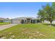 Charming single-story home featuring a well-manicured lawn, attached garage and inviting yellow front door at 6006 Country Walk Ln, Winter Haven, FL 33880