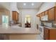 Traditional kitchen with light countertops, wood cabinets, white appliances, and an open view to the dining room at 6006 Country Walk Ln, Winter Haven, FL 33880
