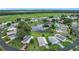 Wide aerial perspective of the community, highlighting the pond, recreation, homes, and greenery at 6044 Grand Oaks Se Dr, Winter Haven, FL 33884