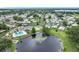 Aerial view of a community lake with pool, recreation area, and neatly arranged homes at 6044 Grand Oaks Se Dr, Winter Haven, FL 33884
