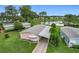 Aerial view showcasing the charming home, lush landscape, and a scenic pond nearby at 6044 Grand Oaks Se Dr, Winter Haven, FL 33884