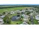 Picturesque community featuring a serene lake, a sparkling pool, and lush greenery at 6044 Grand Oaks Se Dr, Winter Haven, FL 33884