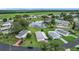 An aerial view showcasing the community with a lake, pool, and well-kept homes at 6044 Grand Oaks Se Dr, Winter Haven, FL 33884