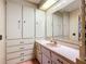 Bathroom vanity with ample storage, mirrors, and decorative trim at 6044 Grand Oaks Se Dr, Winter Haven, FL 33884