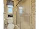 Practical bathroom with updated fixtures, glass shower, and classic wallpaper at 6044 Grand Oaks Se Dr, Winter Haven, FL 33884