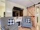 Cozy bedroom sitting area with checkered chairs, electric fireplace, and sliding wood door at 6044 Grand Oaks Se Dr, Winter Haven, FL 33884
