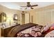 Comfortable bedroom featuring a floral bedspread, dresser, and a well lit mirror at 6044 Grand Oaks Se Dr, Winter Haven, FL 33884