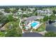 Aerial view showcasing a community pool, clubhouse, and tennis courts in a lush setting at 6044 Grand Oaks Se Dr, Winter Haven, FL 33884