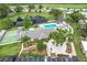Community center with a pool, tennis courts, scenic landscaping, and parking at 6044 Grand Oaks Se Dr, Winter Haven, FL 33884