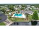 Aerial shot of a community pool area with ample lounge seating, lush greenery, and nearby water access at 6044 Grand Oaks Se Dr, Winter Haven, FL 33884