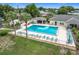 Overhead view of a sparkling community pool with lounge chairs and lush tropical landscaping at 6044 Grand Oaks Se Dr, Winter Haven, FL 33884