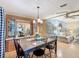 Bright dining room featuring a wooden table, chandelier, and a view into the living room at 6044 Grand Oaks Se Dr, Winter Haven, FL 33884