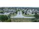 Aerial view of a street surrounded by houses, trees, and lush greenery in a community at 647 Washington Way, Haines City, FL 33844