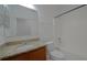 A full bathroom with a granite countertop, wooden cabinets, and a shower and tub combo at 647 Washington Way, Haines City, FL 33844