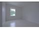 A bright bedroom with neutral paint, tile flooring, and a window providing natural light at 647 Washington Way, Haines City, FL 33844