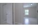 Hallway view featuring white trim, doors, and neutral walls that lead to a naturally lit room at 647 Washington Way, Haines City, FL 33844