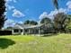 A spacious backyard view with a screened pool and lanai connected to the house, and a lush lawn at 7200 Green Pine Ct, Orlando, FL 32819