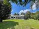 A spacious backyard view with a screened pool and lanai connected to the house, and a lush lawn at 7200 Green Pine Ct, Orlando, FL 32819