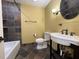 A modern bathroom with a tub, toilet and an elegant sink with dark fixtures at 7200 Green Pine Ct, Orlando, FL 32819