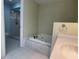 Bright bathroom featuring a tiled shower, soaking tub, and modern fixtures at 7200 Green Pine Ct, Orlando, FL 32819