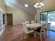 Sun-filled dining room with hardwood floors, table set for four, and a view to the backyard pool at 7200 Green Pine Ct, Orlando, FL 32819
