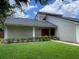 Traditional-style home with a red front door, green lawn, and manicured shrubbery at 7200 Green Pine Ct, Orlando, FL 32819