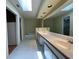 Bathroom featuring a skylight, recessed lighting, tile floors, and a double vanity with a large mirror at 7200 Green Pine Ct, Orlando, FL 32819