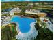Aerial view of a resort-style community pool, splashpad, clubhouse, and surrounding green spaces at 726 Longboat, Davenport, FL 33896
