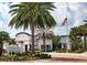 Amenity center at The Enclaves with lush landscaping, an American flag and palm trees at 726 Longboat, Davenport, FL 33896