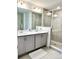 Bathroom featuring double sinks, gray cabinetry, and a glass shower enclosure at 726 Longboat, Davenport, FL 33896