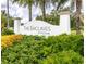 Welcoming entrance sign to The Enclaves at Festival amidst lush landscaping and swaying palm trees at 726 Longboat, Davenport, FL 33896