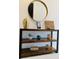 Console table with decorative items in the entry, with a round mirror above it to add character at 726 Longboat, Davenport, FL 33896