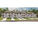 Exterior view of white townhomes with attached garages, manicured lawns, and neutral roofs at 726 Longboat, Davenport, FL 33896