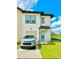 Two-story home with a modern white exterior, a front-facing garage, and manicured lawn at 726 Longboat, Davenport, FL 33896