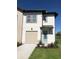 Charming two-story home with a one car garage, a well-manicured lawn, and blue door at 726 Longboat, Davenport, FL 33896