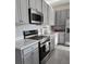 Modern kitchen featuring stainless steel appliances, gray cabinets, mosaic backsplash, and stone countertops at 726 Longboat, Davenport, FL 33896