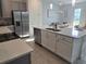 Bright kitchen with stainless steel appliances, an island with a sink, and white cabinets for storage at 726 Longboat, Davenport, FL 33896